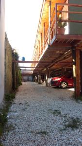 a red car parked in a parking lot next to a building at Cabañas del Rio in Gualeguaychú