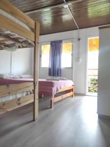 a bedroom with two bunk beds and two windows at Cabañas del Rio in Gualeguaychú