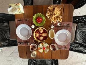 a wooden table with plates and bowls of food on it at White House Boutique Sharm in Sharm El Sheikh