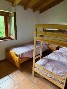 a bedroom with two bunk beds and a window at Baita del Silenzio in Miazzina