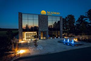 un grande edificio con un'insegna di notte di Hotel MADRID a Krzemionka