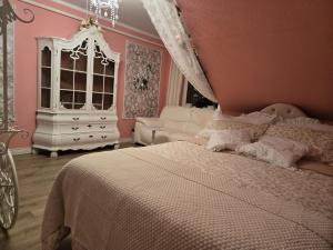 a bedroom with a white bed and a white dresser at Gästezimmer vom Restaurant Saustall in Mestlin +1 photo