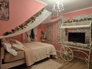 a pink bedroom with a bed and a tv at Gästezimmer vom Restaurant Saustall in Mestlin