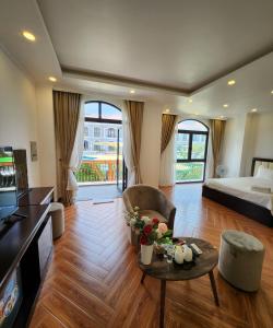 a living room with a bed and a table with flowers at BREAKING DAWN- TAEYANG Hotel Phú Quốc in Phú Quốc