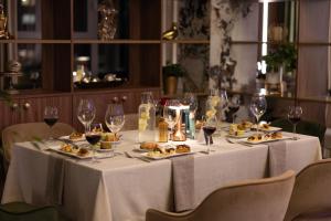 a table with plates of food and wine glasses at Suncity Hotel & SPA in Šiauliai