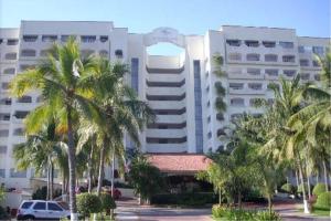 ein großes Gebäude mit Palmen davor in der Unterkunft Departamento 522 con playa dentro de Hotel en Ixtapa in Ixtapa