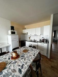 a kitchen with a table with a table cloth on it at La GOELETTE in Quend-Plage