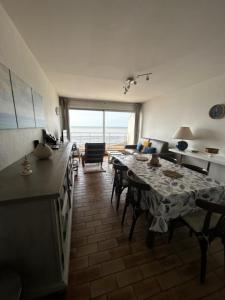 a living room with a table and a dining room at La GOELETTE in Quend-Plage