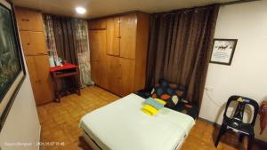 a small room with a bed and a table at Kochimoto Homestay in Baguio