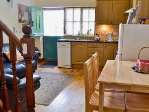 a kitchen with a table and a refrigerator at Jasmine Cottage - 30503 in West Firle