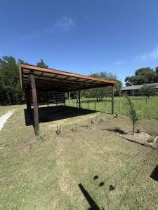 a wooden structure with a roof on a grass field at Ideal para parejas en Anisacate in Villa Anizacate +5 photos