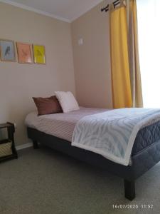 a bedroom with a bed with a yellow curtain at Casa CQ in Coquimbo