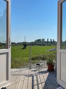 an open door to a porch with a view of a field at Gårdsfrun in Löttorp