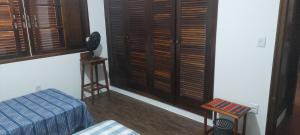 a room with a bed and a window with wooden shutters at Quarto Suíte Pitanga in Atibaia