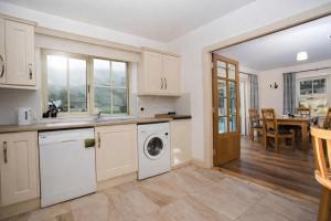 a kitchen with a washer and dryer and a dining room at 4 Bedroom House By Travel Lets Holiday Homes Downings With Beautiful Ocean View in Downings