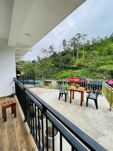 a balcony with tables and chairs and a train at Ella 78 Resort in Ella