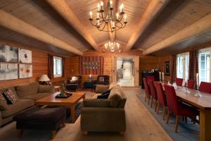 a living room with a chandelier and a couch and chairs at Geilolia Hyttetun in Geilo
