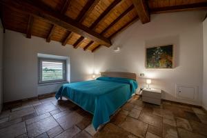 a bedroom with a bed with a blue blanket at Agriturismo I Due Casali in Vetralla +110 photos