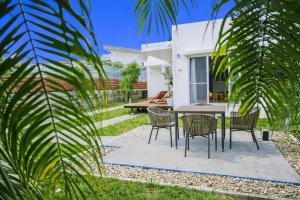 a patio with chairs and a table in front of a house at Third Place Onna Tancha Villa in Onna