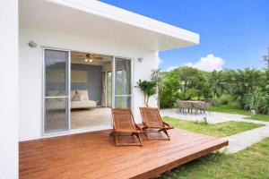 two chairs sitting on a wooden deck next to a bedroom at Third Place Onna Tancha Villa in Onna