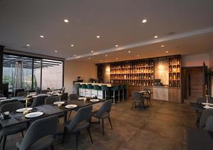 a restaurant with tables and chairs and a bar at Lyv Resort and Venue in Şannīn