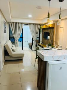a kitchen and living room with a couch and a table at Marinas Praia Flat 005 in João Pessoa
