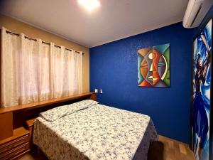 a bedroom with a bed and a painting on the wall at Pousada Complexo Girassol in Dourados +8 photos