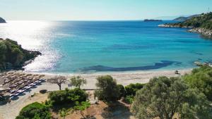 Luftaufnahme eines Strandes mit Liegestühlen und dem Meer in der Unterkunft Paramithenio Village Beach Resort & Spa in Agio Apóstoloi