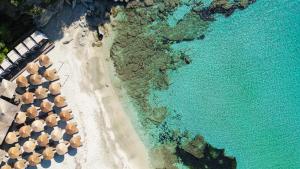 Eine Draufsicht auf einen Strand mit Sonnenschirmen und dem Meer in der Unterkunft Paramithenio Village Beach Resort & Spa in Agio Apóstoloi