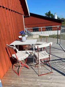 a table and chairs on a deck with a fence at Gårdsfrun in Löttorp