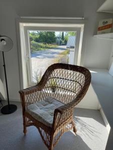 a wicker chair sitting in front of a window at Gårdsfrun in Löttorp +20 photos