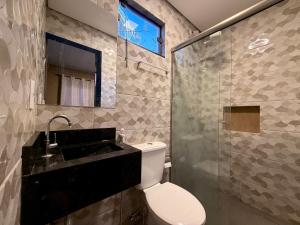 a bathroom with a toilet and a sink and a shower at Pousada Complexo Girassol in Dourados