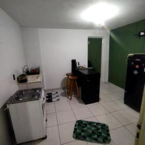 a kitchen with a stove and a green wall at Suite com cozinha 250m do centro in São Thomé das Letras