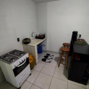 a small kitchen with a stove and a table at Suite com cozinha 250m do centro in São Thomé das Letras