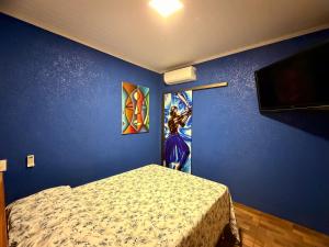 a bedroom with a bed and a painting on the wall at Pousada Complexo Girassol in Dourados