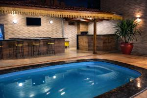 a swimming pool with a bar and a bar at Pousada Complexo Girassol in Dourados