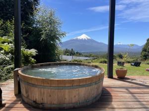a hot tub with a mountain in the background at Ampe Lodge in Puerto Varas