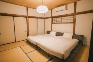 a bedroom with a large bed in a room at 網代温泉源泉かけ流し 阿治古の宿 in Atami