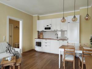 a kitchen with white cabinets and a wooden table at Eine gemütliche Ferienwohnung in Kurort Gohrisch +35 photos