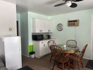 a kitchen with a table and chairs and a kitchen with a refrigerator at Mountain View Motel in Barrys Bay