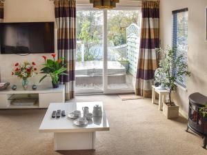 a living room with a tv and a table at Highview in North Walsham