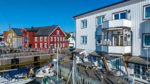 a group of buildings and boats in a marina at Hellandsøy apartment, Henningsvær in Henningsvær