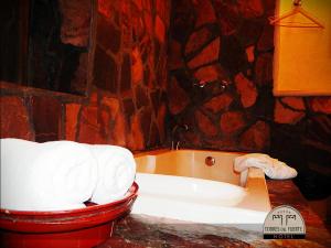 a bath tub in a bathroom with a stone wall at Hotel Torres Del Fuerte in El Fuerte +125 photos