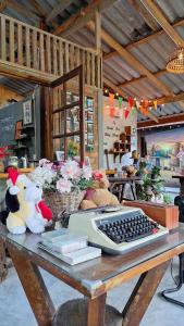 a desk with a computer keyboard and stuffed animals on it at BaanRaiChayKhaoFarmStay in Nakhon Si Thammarat +34 photos