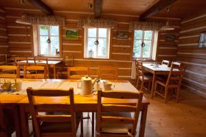 a restaurant with wooden tables and chairs and windows at Penzion Modrý Pavilon in Dolní Malá Úpa