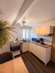 a kitchen with white cabinets and a wooden floor at Wohnen in der Altstadt - Wohnungen und Studio in Gundelsheim