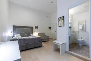 a bedroom with a bed and a couch and a mirror at Il Tesoro Smart Suite & SPA in Naples