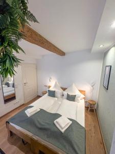 a bedroom with a large bed with two towels on it at Wohnen in der Altstadt - Wohnungen und Studio in Gundelsheim