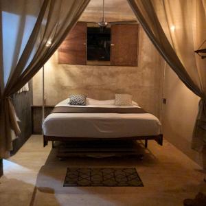 a bedroom with a bed in a room with curtains at Casa MANDALA in Santa María Colotepec