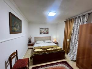a bedroom with a bed and a chair in it at Vila Korcari Dardhe in Dardhë